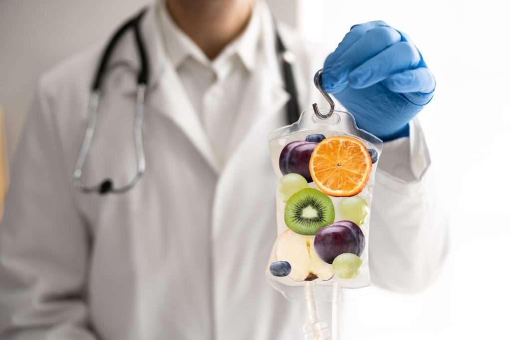 Doctor holding a vitamin IV infusion bag representing nutrient infusion therapy for hydration, immune support, energy, and overall wellness
