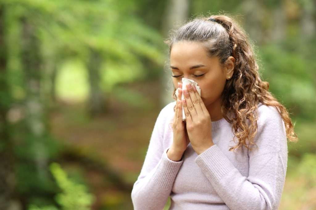 Woman experiencing seasonal airborne allergy symptoms from pollen