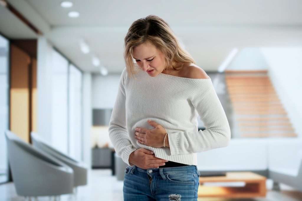 Woman with stomach pain representing digestive issues, IBS, bloating, and gastrointestinal disorders