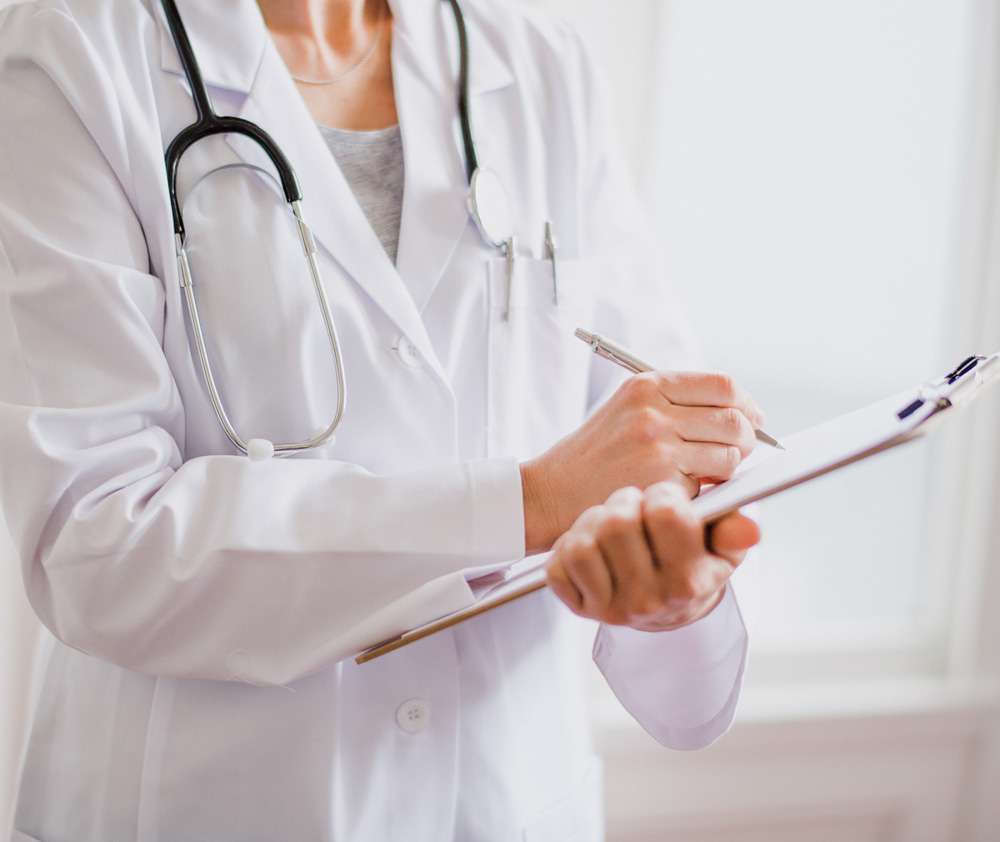 Healthcare provider reviewing a patient's medical records and personalized treatment plan during a comprehensive wellness consultation
